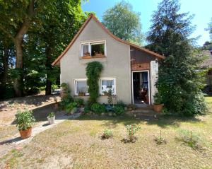 a small house with plants in a yard at Ferienwohnung Scheffler in Krakvitz