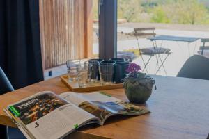 an open book on a table with glasses and a vase at Bardo CAMP in Bardo