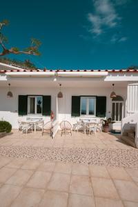 a patio with tables and chairs in front of a building at Appartamenti Baia di Citara in Forio d'Ischia