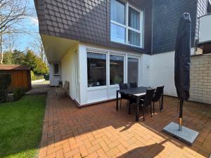 a patio with a table and chairs in front of a house at Nr 64 - Ferienhaus Krabbe 12 in Carolinensiel