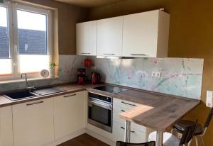 a kitchen with white cabinets and a marble counter top at Sonnenhof Krausnick in Krausnick