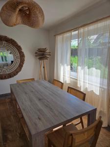 a dining room table with chairs and a large window at Casa Lumina in Lachapelle-sous-Rougemont