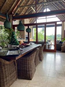 a kitchen with a large island with wicker chairs at Vaal River Front Lodge in Sasolburg