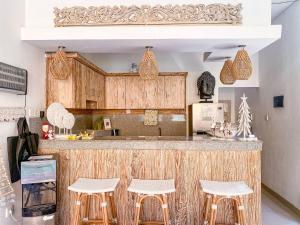 a kitchen with a counter with stools at Villa Aniela Legian in Legian