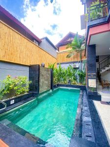 a swimming pool in front of a building at Villa Aniela Legian in Legian