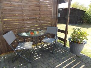two chairs and a table in front of a fence at Ferienwohnung Mohnblume in Gerswalde