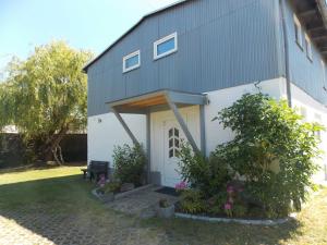 a house with a white door and some plants at Ferienwohnung Mohnblume in Gerswalde