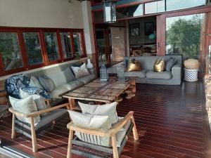 a living room with a couch and a table and chairs at Vaal River Front Lodge in Sasolburg