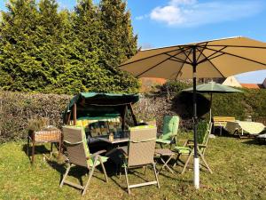 a table with chairs and an umbrella in the grass at Villa Seenswert in Lauta