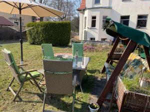 a group of chairs and an umbrella in a yard at Villa Seenswert in Lauta
