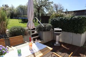 a patio with a table and an umbrella and a grill at Ferienhaus Frieda mit 2 Schlafzimmern in Sagard +43 photos