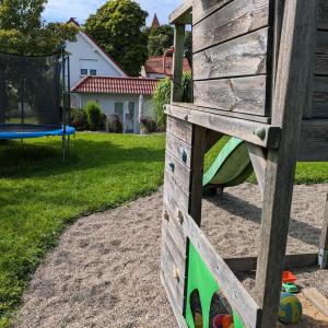 a wooden play structure in a yard with a playground at Ferienhaus Frieda mit 2 Schlafzimmern in Sagard