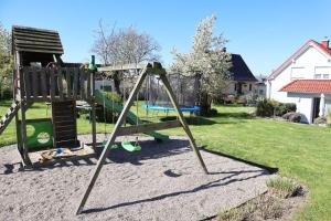 a playground with a swing set in a yard at Ferienhaus Frieda mit 2 Schlafzimmern in Sagard
