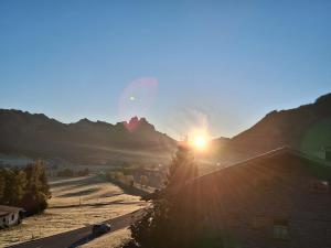 a sunset over a mountain with the sun in the sky at Hochtal Apartments in Tannheim