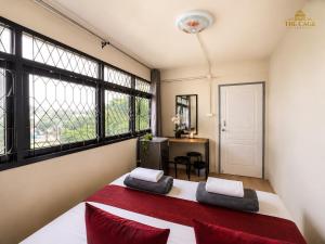 a bedroom with a bed with red pillows and windows at The Cage Suites in Bangkok