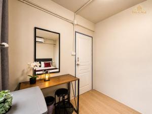 a room with a desk and a mirror at The Cage Suites in Bangkok
