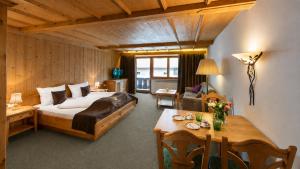a bedroom with a bed and a table in a room at Appartementhaus Leitner in Ehrwald