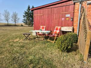 a table and chairs sitting next to a barn at Ferienwohnung Kranichblick in Hoppenrade +9 photos