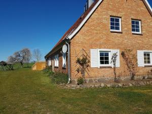 a brick house with a grass yard next to it at Ferienwohnung Kranichblick in Hoppenrade