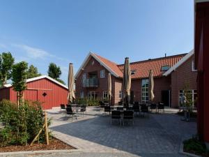 a patio with tables and chairs in front of a building at Sielhof Ditzum 45263 in Ditzum