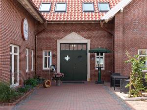 a brick building with a green door and a clock at Sielhof Ditzum 45263 in Ditzum