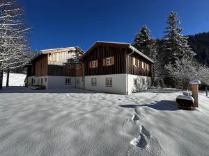 a house in the snow with footprints in the snow at Mitteralm-Kreuth in Kreuth