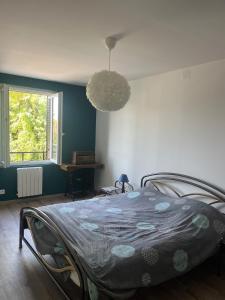 a bedroom with a bed with a blue wall at Chez Paulette - par Happy House in Gouzon