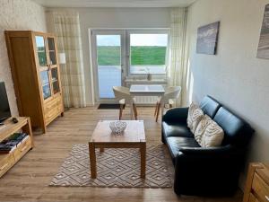 a living room with a couch and a table at Haus Lith - Ferienwohnung Strandläufer in Nordstrand +12 photos