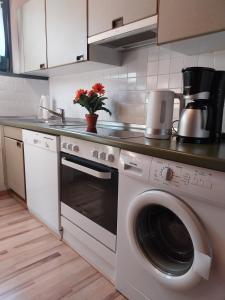 a kitchen with a stove and a washing machine at Nordseenest in Butjadingen