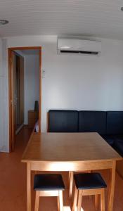 a wooden table with two chairs and a couch at São Pedro de Moel by Campigir in São Pedro de Moel