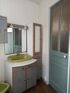 a bathroom with a sink and a mirror and a door at Maison Aux Cailloux in Calais