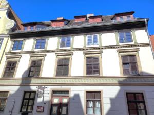a white building with windows on a street at Altstadthaus Stralsund Külpstraße 11 in Stralsund