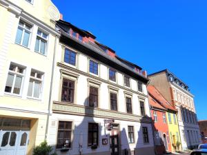 a white building on the side of a street at Altstadthaus Stralsund Külpstraße 11 in Stralsund