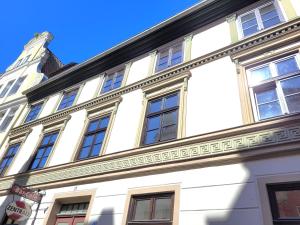 a white building with windows on the side of it at Altstadthaus Stralsund Külpstraße 11 in Stralsund