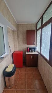 a kitchen with a red stool and a red trash can at Gabriela Studio in Drobeta-Turnu Severin