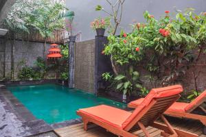 a small swimming pool with a bench and a chair at Villa Mali Legian in Legian