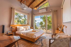a bedroom with a bed and a large window at Seclude Ramgarh Cliff's edge in Rāmgarh