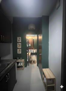 a kitchen with green and white walls and a hallway at Ortigas Uptown Bonifacio CBD Hostel in Sampong