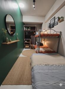 a bedroom with a bunk bed and a mirror at Ortigas Uptown Bonifacio CBD Hostel in Sampong