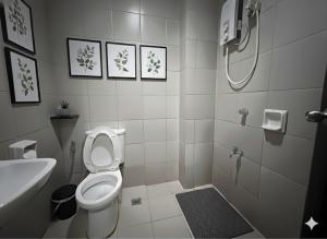 a small bathroom with a toilet and a shower at Ortigas Uptown Bonifacio CBD Hostel in Sampong