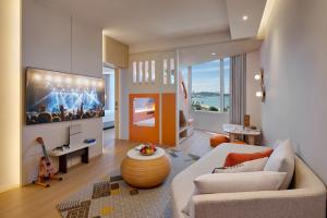 a living room with a large tv on the wall at Hard Rock Hotel Pattaya in Pattaya