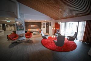a living room with orange chairs and a red rug at Blix Hotel in Vikøyri