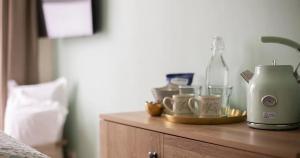 a counter with a coffee maker and cups on it at Hotel Penzance Promenade in Penzance +42 photos