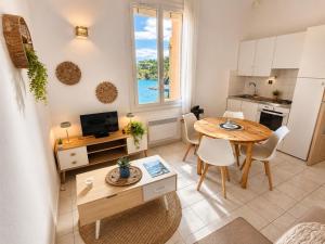 a kitchen and living room with a table and a dining room at Résidence les 4 Horizons in Cerbère