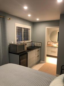 a bedroom with a bed and a kitchen with a microwave at Truffle Ridge Vineyard Stay in Martinborough +7 photos