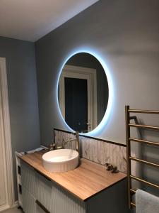 a bathroom with a sink and a round mirror at Truffle Ridge Vineyard Stay in Martinborough