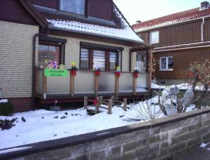 a house with a fence in the snow at Ferienwohnung Anneli Edert in Bad Harzburg