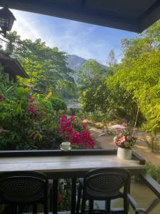 a view of a garden from a porch with chairs and flowers at บ้านชมธาร บ้านสวนสราญชล in Ban Plai Nam (2)