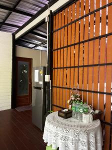 a room with a table and a refrigerator at บ้านชมธาร บ้านสวนสราญชล in Ban Plai Nam (2)
