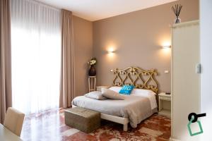a bedroom with a white bed with blue pillows at Hotiday Porto Cesareo Spiaggia in Porto Cesareo